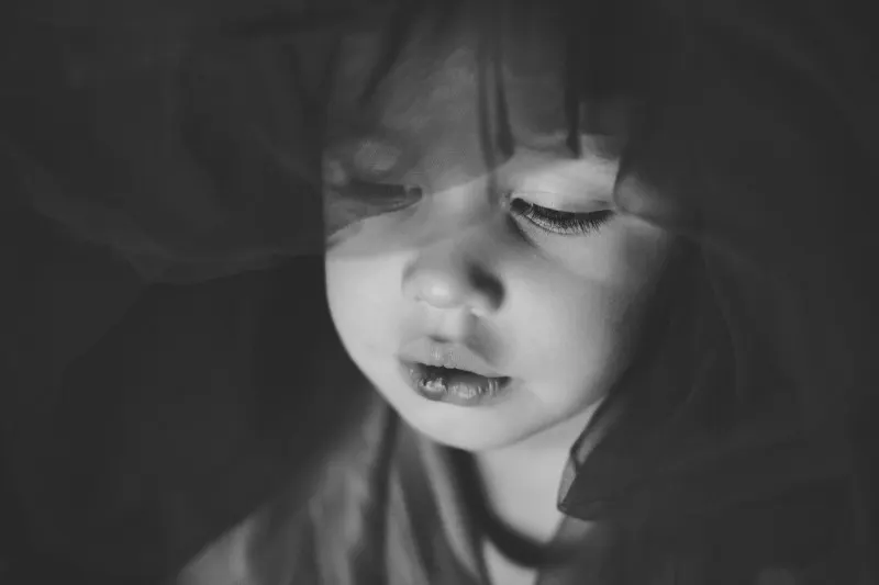 girl with eyes closed behind a translucent veil, black and white