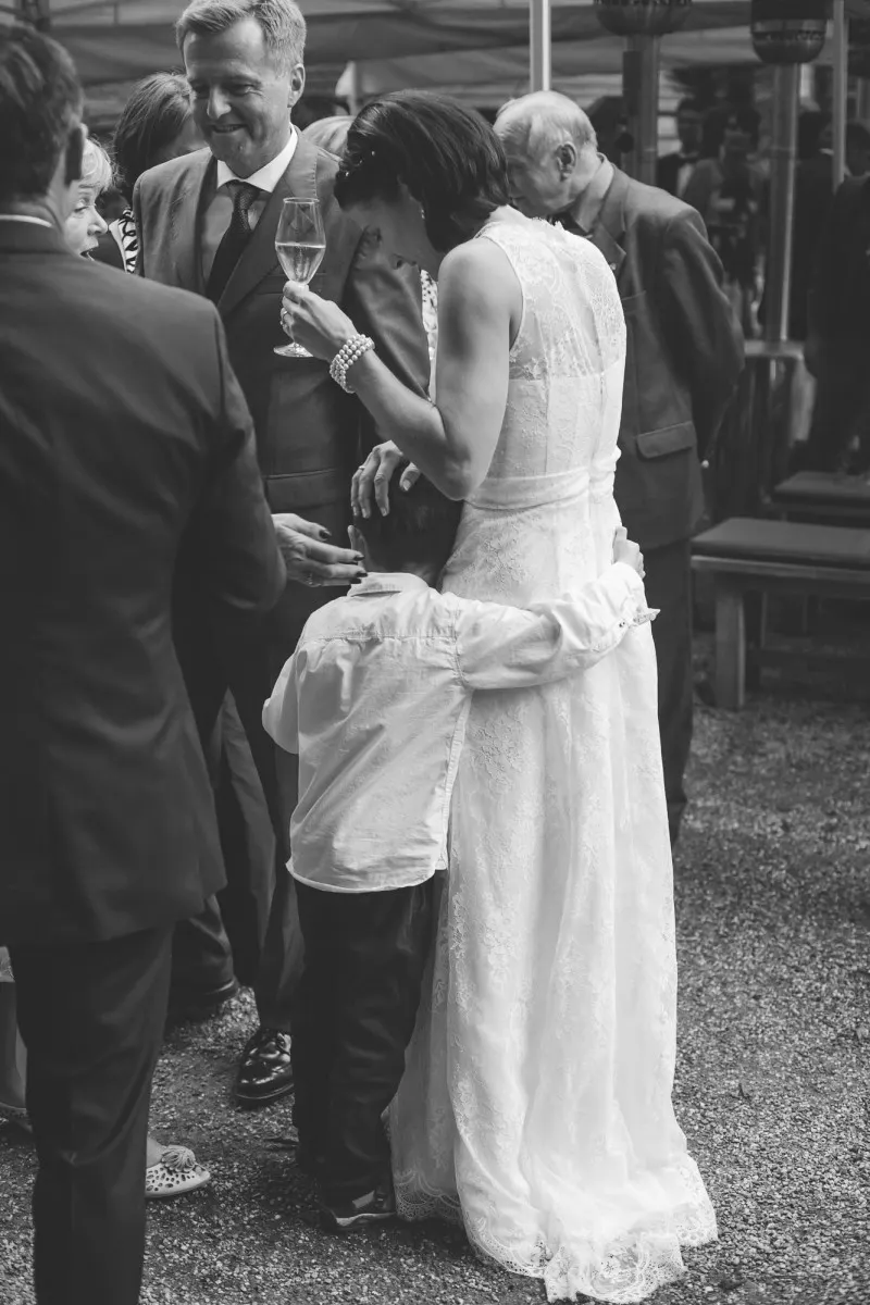 irish german wedding, bride hugging a young boy at the reception, black and white