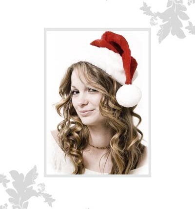 Holiday card portrait of a redhead woman wearing a Santa hat