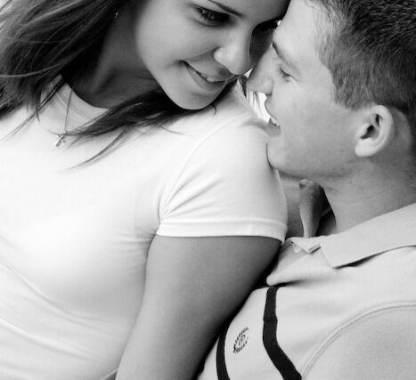 Tender couple portrait touching foreheads and smiling, black and white