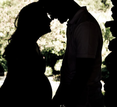 High contrast silhouette of an expectant couple facing each other in a doorway