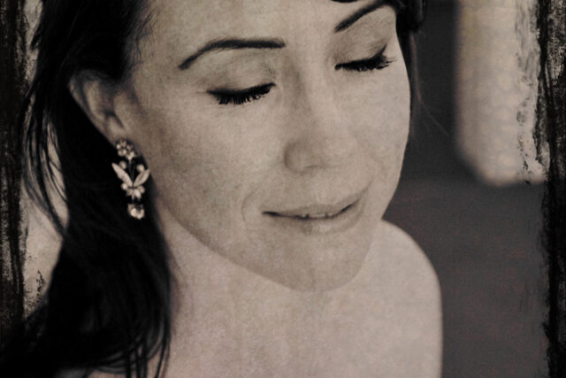 Fine-art portrait of a young woman looking downward, soft sepia toned contest photograph