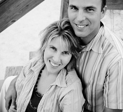 Couple portrait smiling together under a porch post, black and white