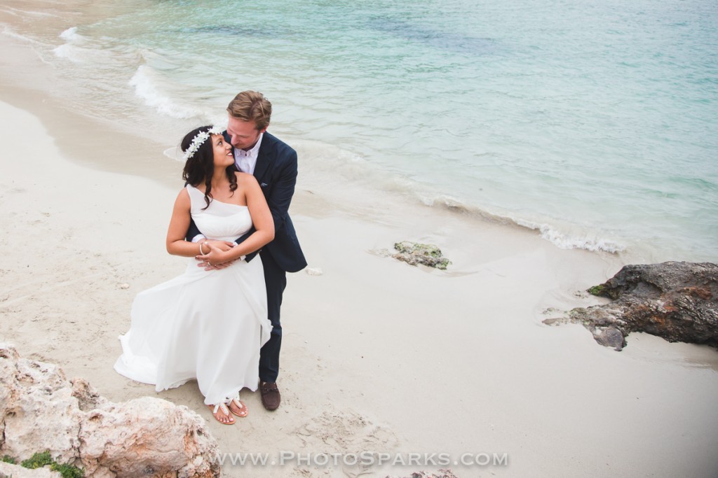 Bride and groom share an intimate kiss on the sandy beach at Cala Sa Nau during their Mallorca wedding.