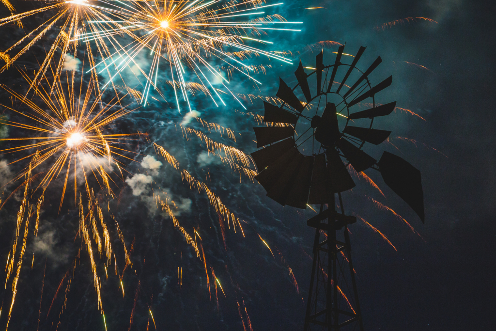 Fireworks bursting behind a silhouetted windmill at the Fourth of July celebration in Kanab Utah