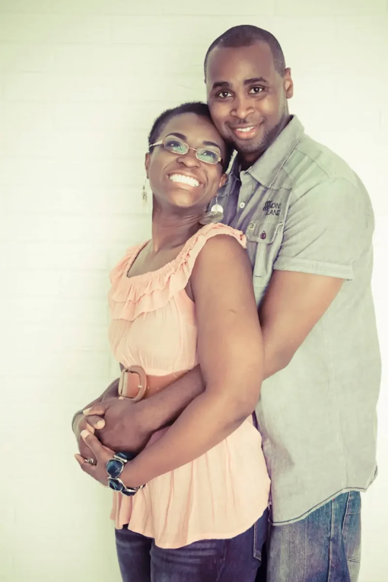 Couple embracing and smiling at a senior-picture studio backdrop